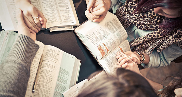 Women's hands shown above open Bibles